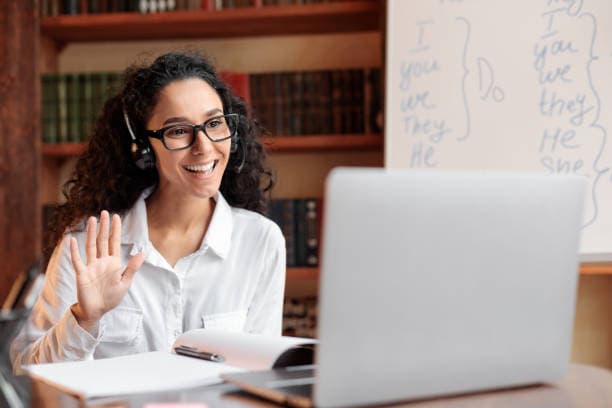 A tutor waving hello at the start of an online lesson